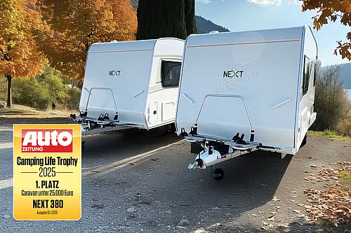 Zwei weiße NEXT 380 Caravans im Herbstlicht mit dem 1 Platz Siegel der Camping Life Trophy 2025 von der Auto Zeitung