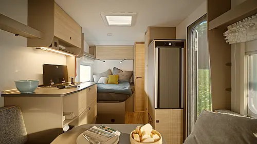 Moderner Innenraum des NEXT Caravan mit heller Holzhaptik, gemütlichem Festbett, Küchenzeile und Blick ins Grüne